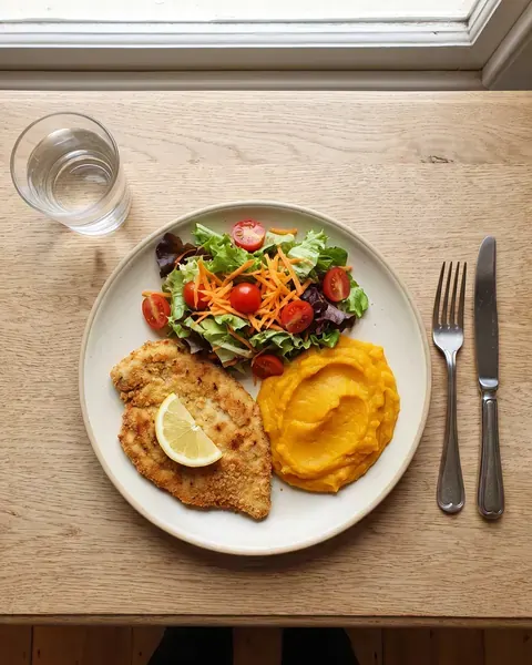 Milanesa de pollo al horno con ensalada y puré de calabaza