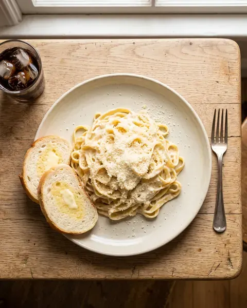 Fideos con crema, queso y pan con manteca